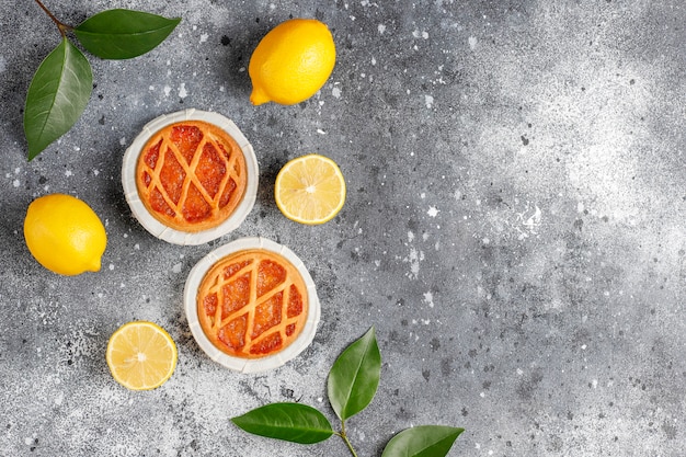 Delicious mini lemon pies with fresh lemons,top view