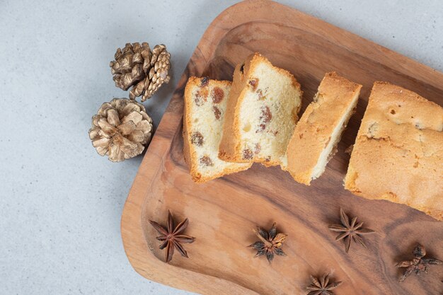 Delicious muffin with raisin and cup of tea on wooden board