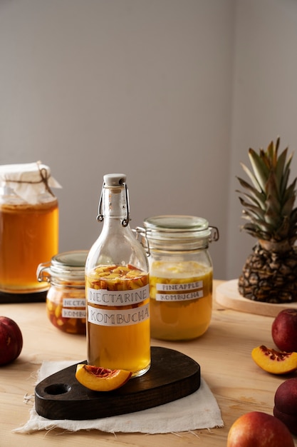 Free photo delicious nectarine kombucha  bottle on table