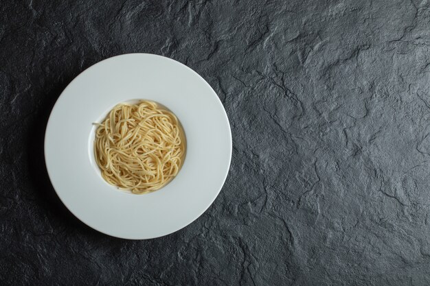 Free Photo delicious noodles in a white plate on black.