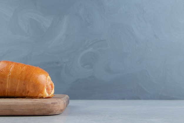 Delicious pastry with sausages on wooden board. 