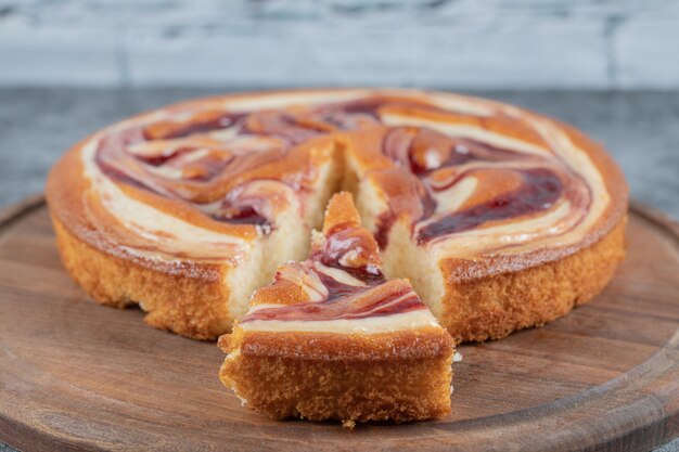 Delicious pie with multiple ingredients on a wooden cutting board