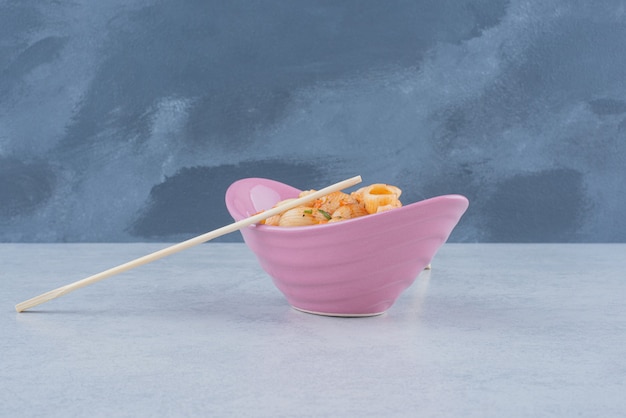 Free Photo delicious pink plate with macaroni and chopsticks on dark surface