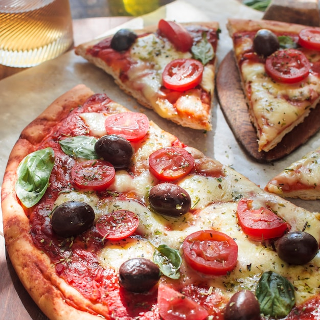 Free photo delicious pizza with cheese and cherry tomato slices on wooden table