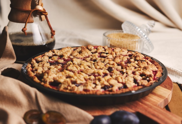 Delicious  Plum pie with Chemex coffee and ingredients with fabric on a wooden table with fabric