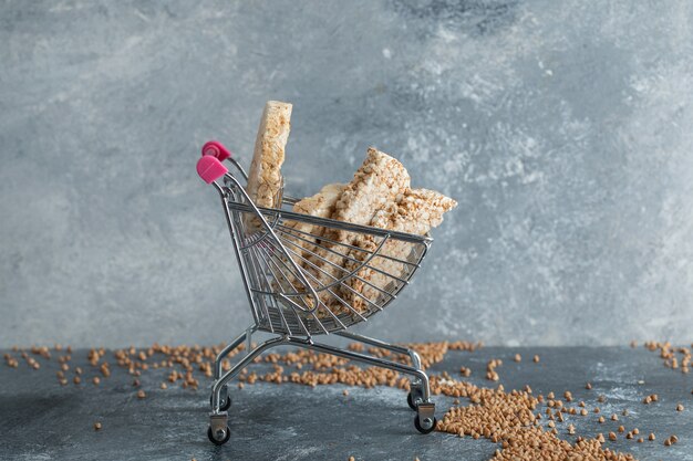 Delicious rice cakes in small shopping cart and scattered buckwheat