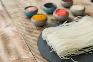 Free photo delicious rice noodles and ingredients in bowl on old wooden texture plank