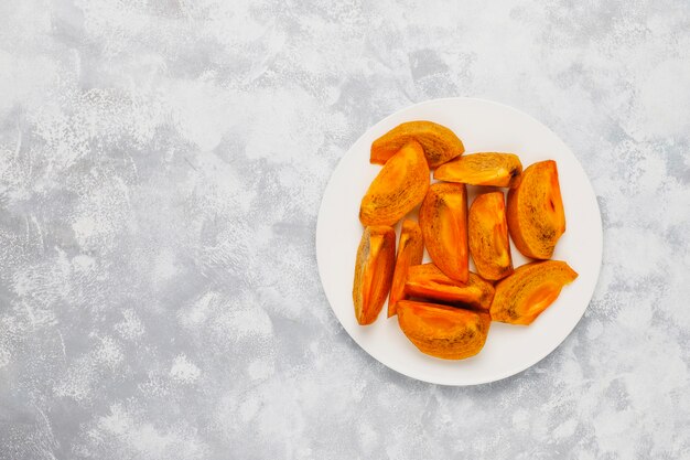 Delicious ripe persimmon fruit on concrete 