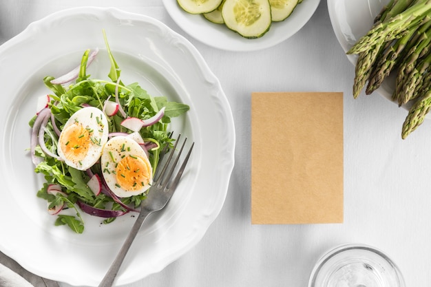 Delicious salad on a white plate with empty card