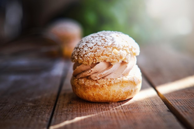 Delicious sandwich cakes with custard creme and powdered sugar on wooden table. Closeup photo shoot.