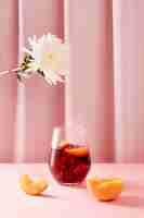 Free photo delicious sangria, peach and flowers assortment