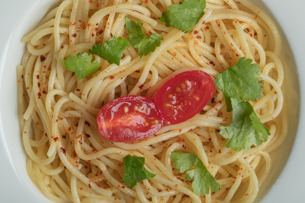 Free photo delicious spaghetti with greens and cherry tomato.