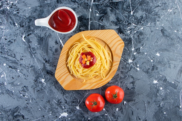 Free photo delicious spaghetti on wooden plate with fresh tomatoes and tomato sauce.