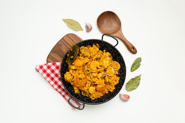 delicious spanish rice in a paella pan on white background