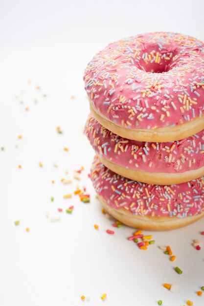 Delicious stacked doughnuts with glazing and sprinkles