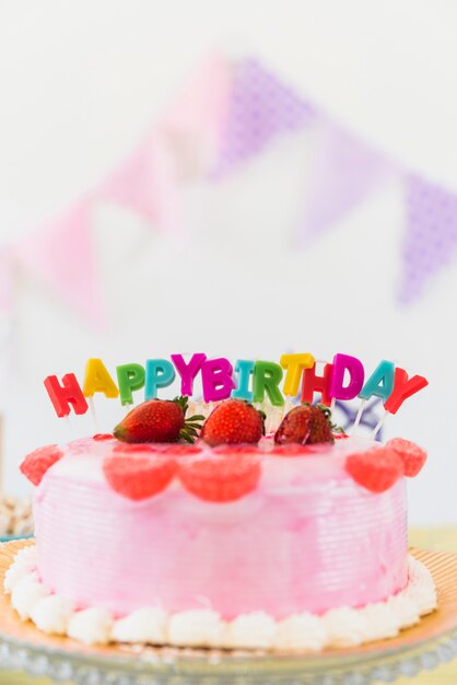 Delicious strawberry birthday cake with colorful candles