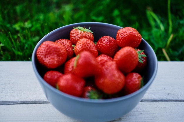 Delicious strawberry in a cup on a wooden desk. Food concept