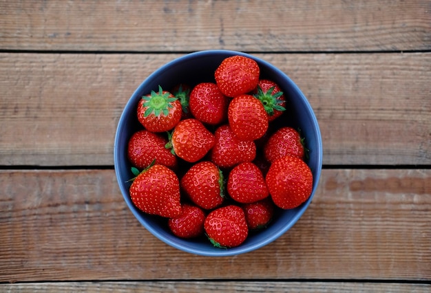 Delicious strawberry in a cup on a wooden desk. Food concept