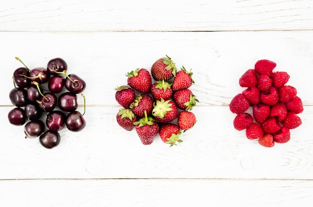 Delicious summer berries on white surface