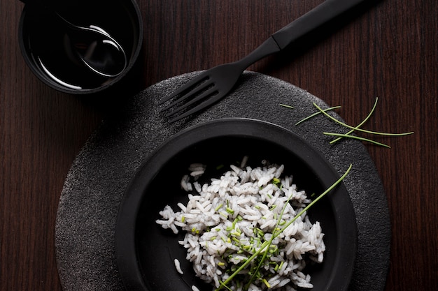 Delicious sushi rice on black plate with fork and soy sauce