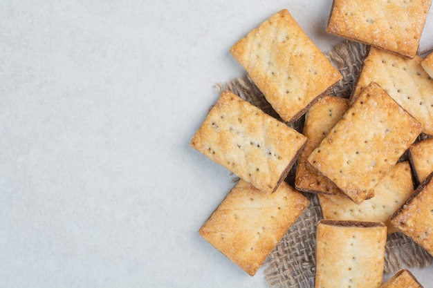 Delicious sweet crackers on sackcloth on white background. High quality photo