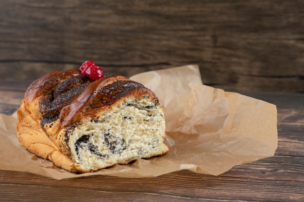 Delicious sweet pastry with chocolate on cooking sheet on wooden surface.