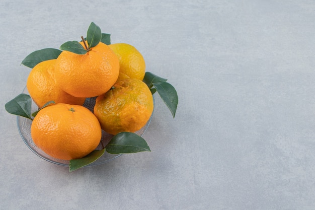 Delicious tangerine fruits on glass plate. 