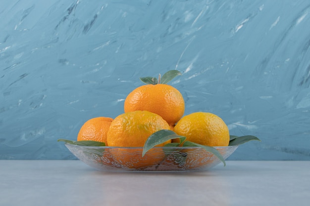 Delicious tangerine fruits on glass plate