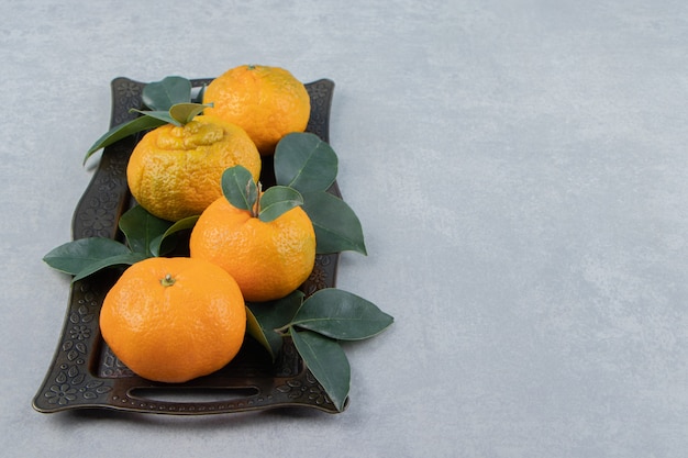 Delicious tangerine fruits on metal tray