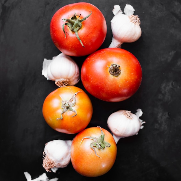 Free Photo delicious tomatoes and garlic on black background