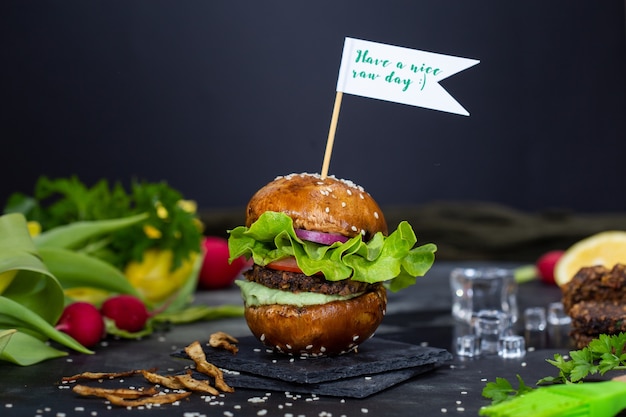 Free Photo delicious vegan hamburger with a sign "have a nice raw day" on the stick