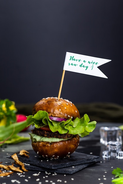 Free Photo delicious vegan hamburger with a sign "have a nice raw day" on the stick