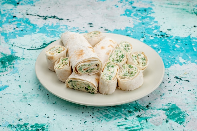 Free Photo delicious vegetable rolls whole and sliced on bright-blue, food meal roll vegetable snack