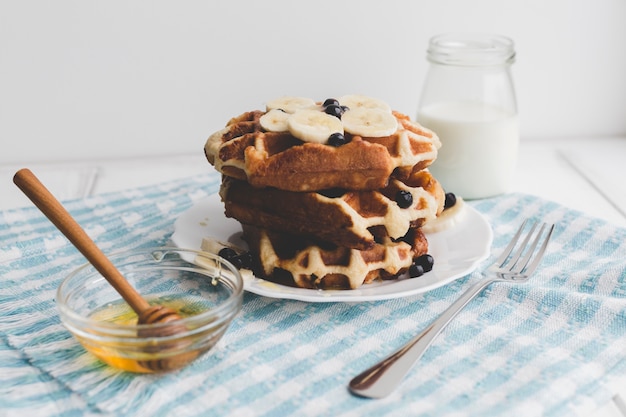 Delicious waffles near honey and dairy