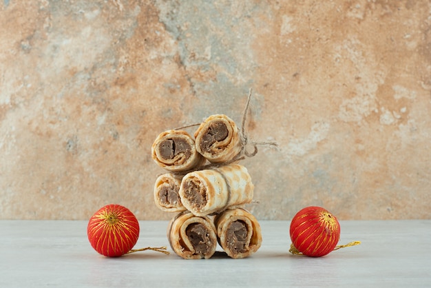 Free photo delicious waffles with two red christmas balls on marble background. high quality photo