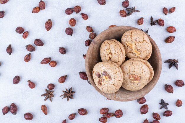 Delicious walnut cookies in bowl with rosehips.