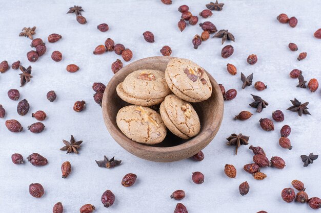 Delicious walnut cookies in bowl with rosehips.