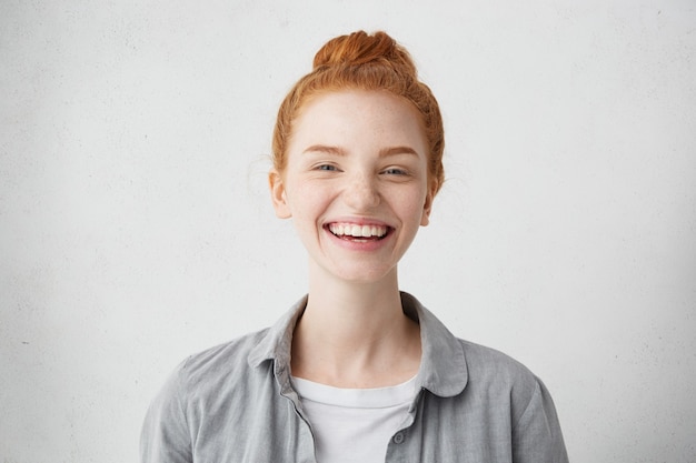 Delightful redhead female with beautiful freckled face casually dressed smiling