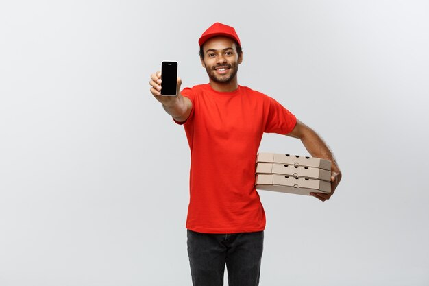 Delivery Concept - Portrait of Handsome African American delivery man or courier showing tablet on you to check the order. Isolated on Grey studio Background. Copy Space.