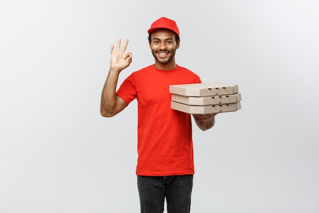 Delivery Concept - Portrait of Handsome African American Pizza delivery man. Isolated on Grey studio Background. Copy Space.