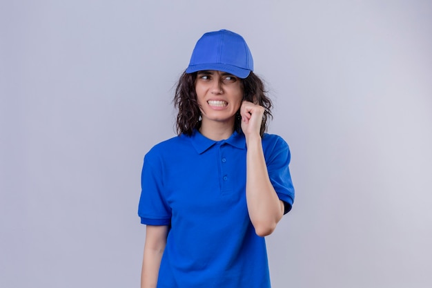 Free Photo delivery girl in blue uniform and cap looking confused and frustrated standing on isolated white