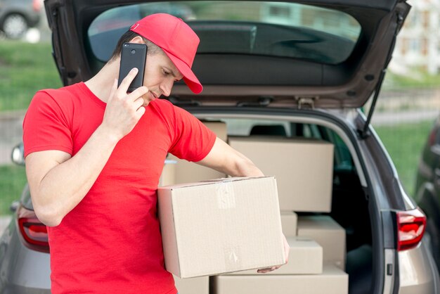 Delivery guy with phone and box