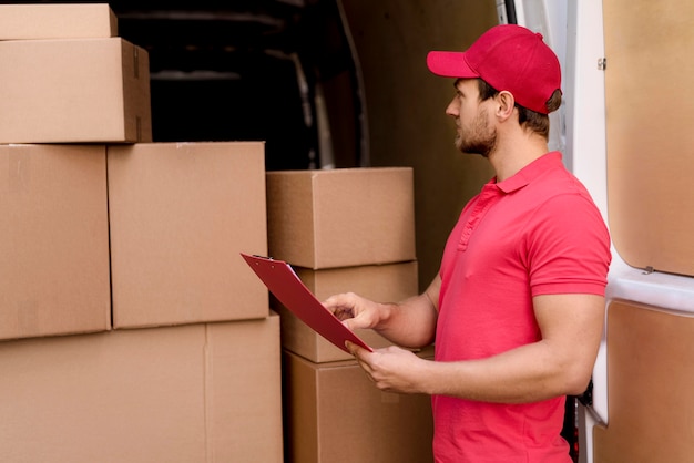 Free Photo delivery man checking packages list