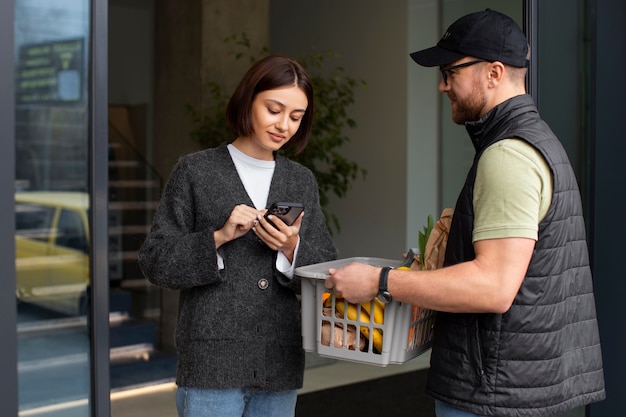 Free photo delivery man giving groceries order to customer