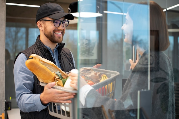 Free photo delivery man giving groceries order to customer