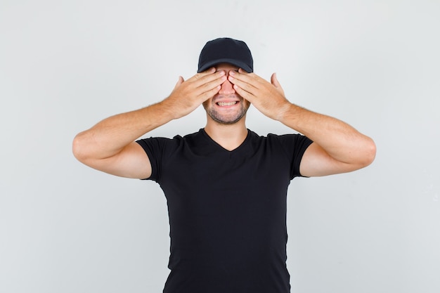 Delivery man holding hands on eyes in black t-shirt