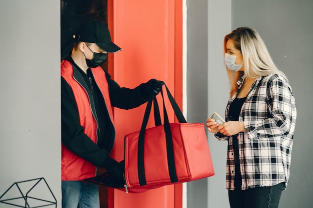 Delivery man in a medic mask with woman