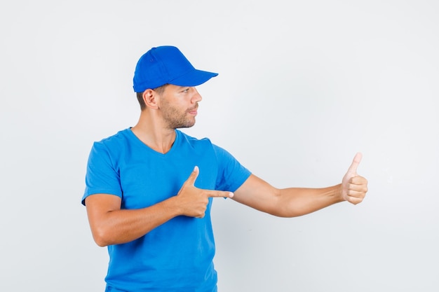 Delivery man pointing at his thumb up in blue t-shirt