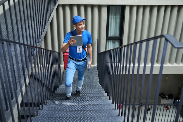 Delivery man searching for right apartment in building