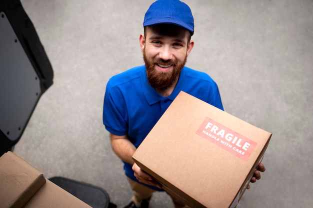 Free photo delivery man with boxes medium shot